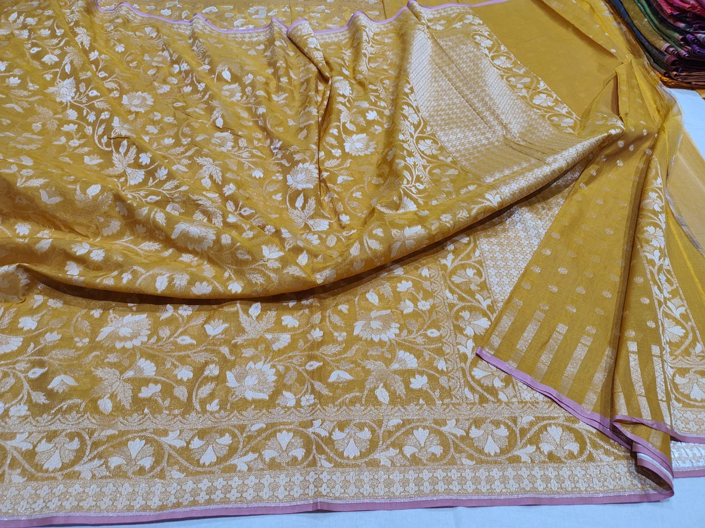 Yellow fabric with white floral patterns on a white background