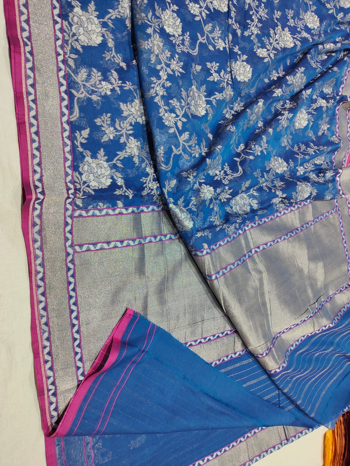 Blue and gray saree with floral patterns on a neutral background